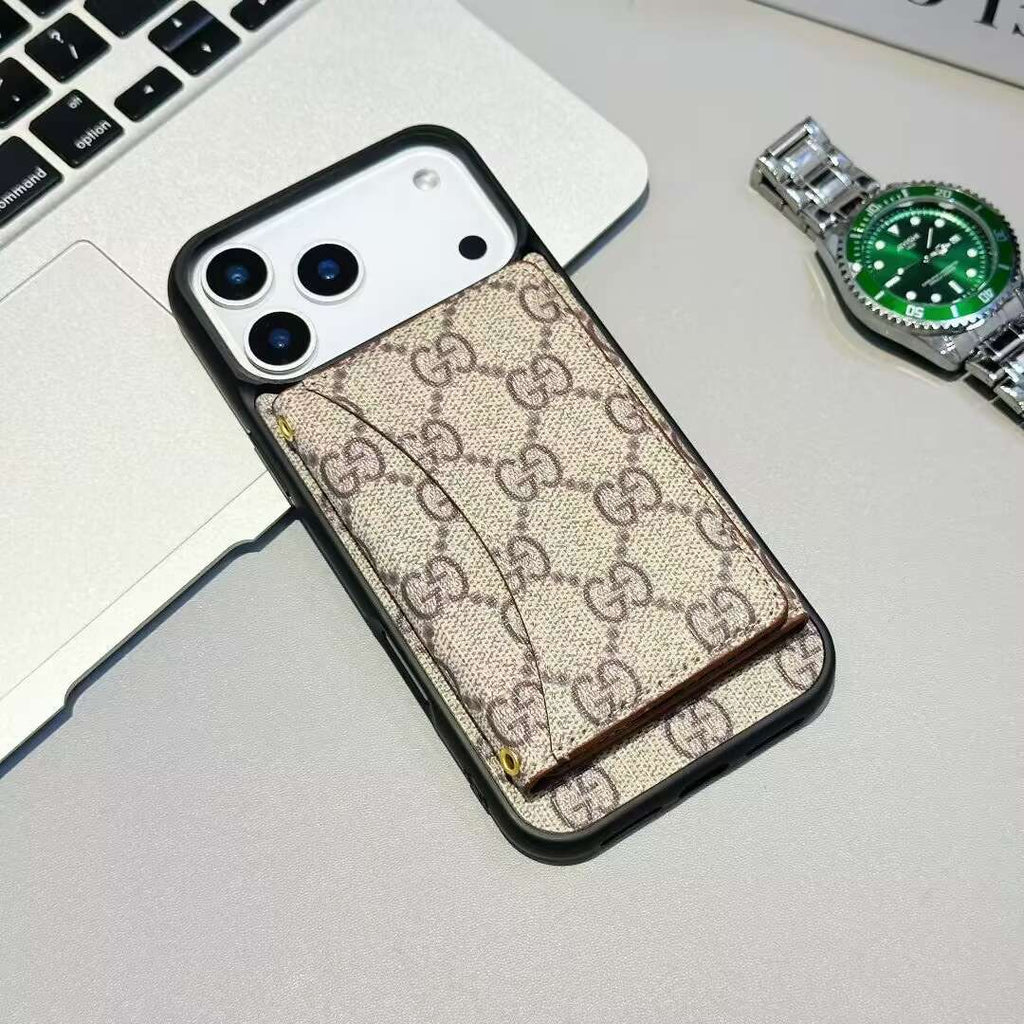 Phone case with Gucci pattern on a desk with a laptop and watch.
