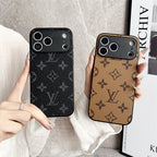 Two phone cases with a monogram pattern held by hands against a neutral background.