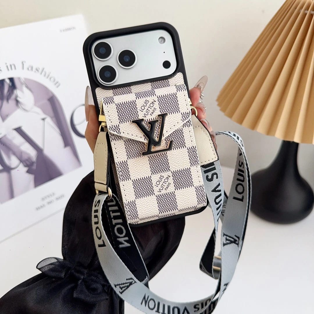 Louis Vuitton phone case with strap held by a hand on a light background